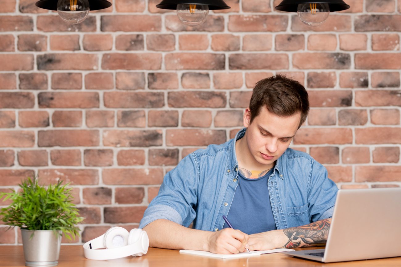 Man sitting in front of laptop making a home inventory list