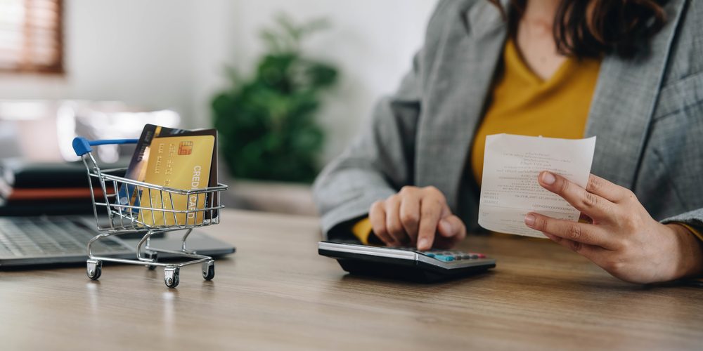 Woman doing finances: holding money and using a calculator