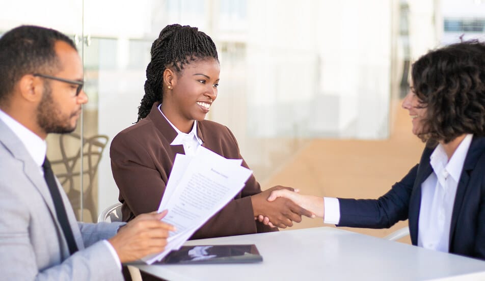 A professional meeting, featuring a handshake.