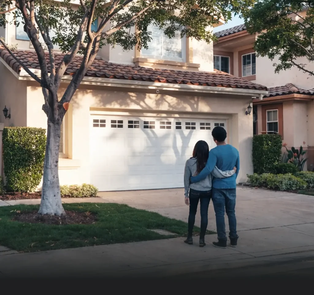 happy homeowners staring at their home square shot